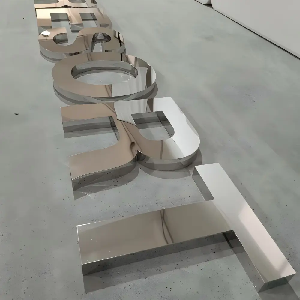 Polished mirror chrome dimensional letters laid on concrete floor at an angle