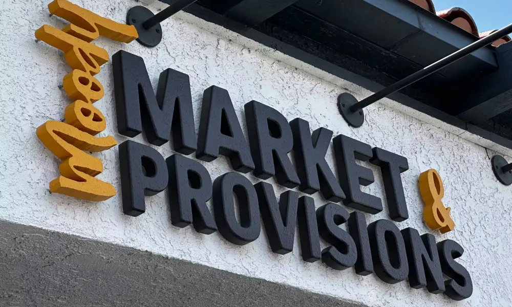 Moody Market and Provisions dimensional storefront sign in black and yellow