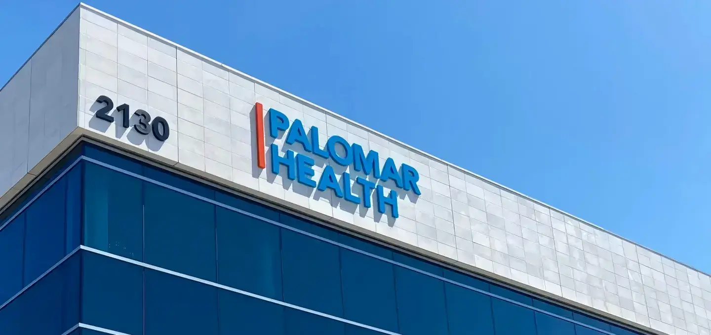 Palomar Health blue illuminated channel letters installed on rooftop building facade