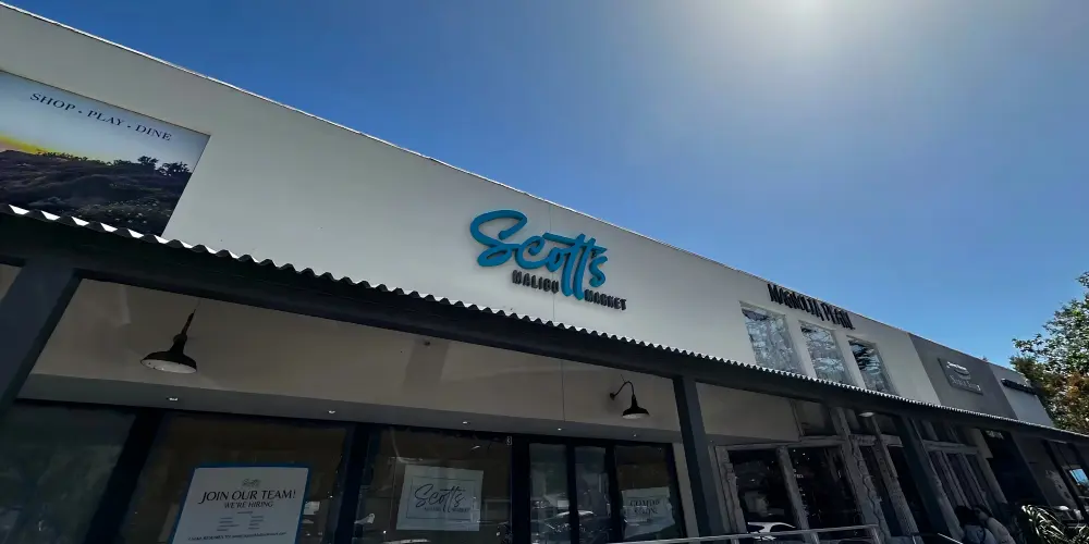 Scott's Malibu Market blue script channel letter sign on storefront facade