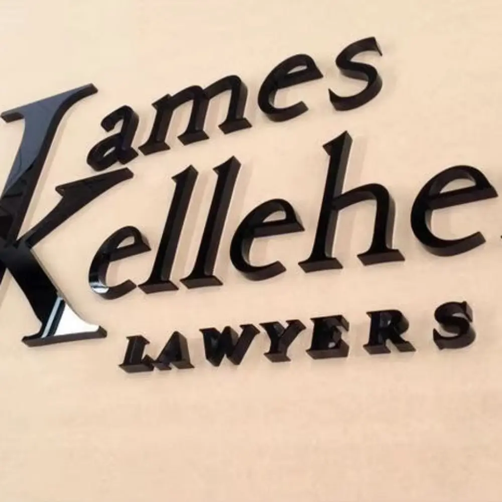 Glossy black James Kelleher Lawyers acrylic letters mounted on a cream wall