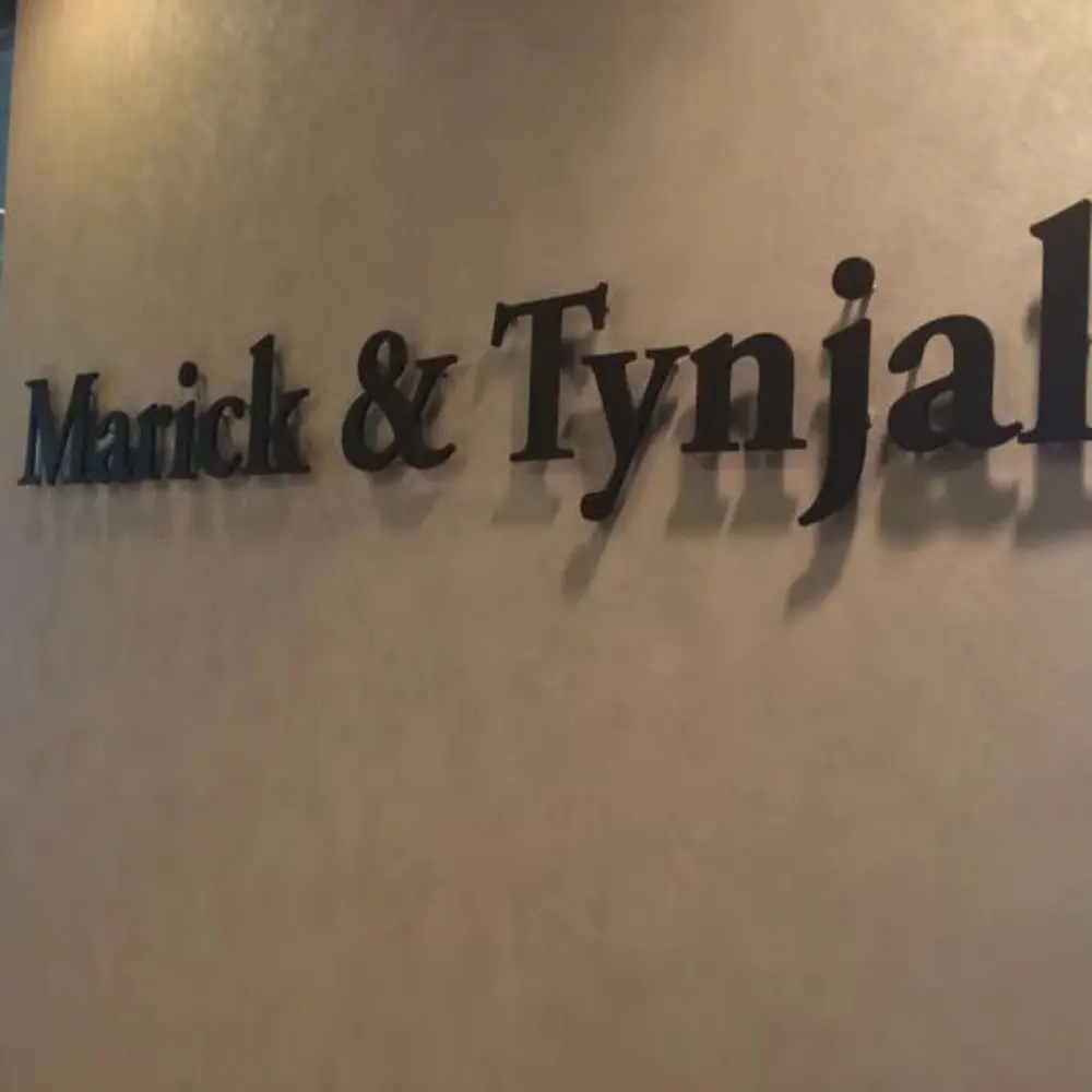 Black acrylic name lettering individually mounted on a beige interior wall