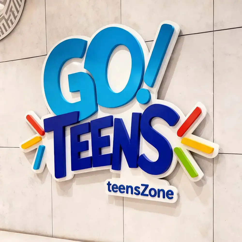 Colorful layered acrylic Go Teens wall sign with blue letters and decorative accents
