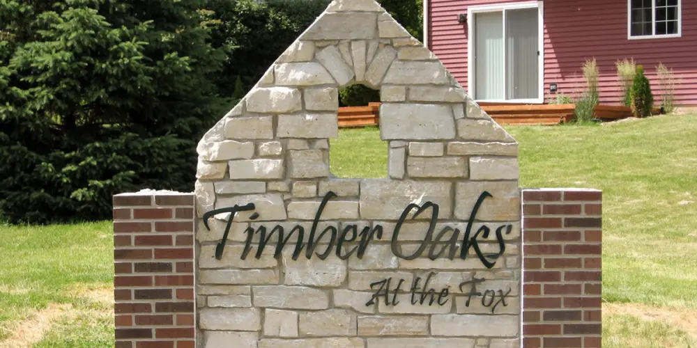 Timber Oaks at the Fox stone monument sign with brick pillars in front of house