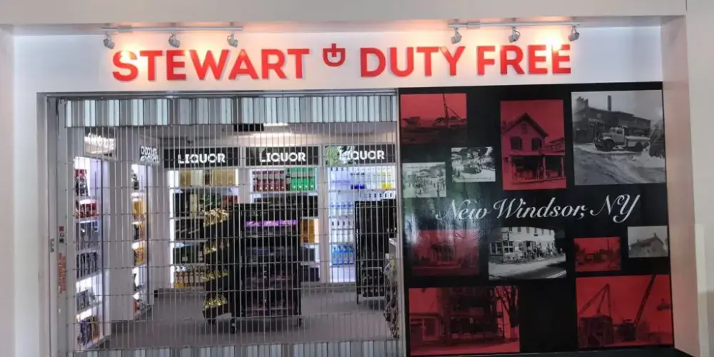 Red Stewart Duty Free acrylic letters displayed above a retail entrance