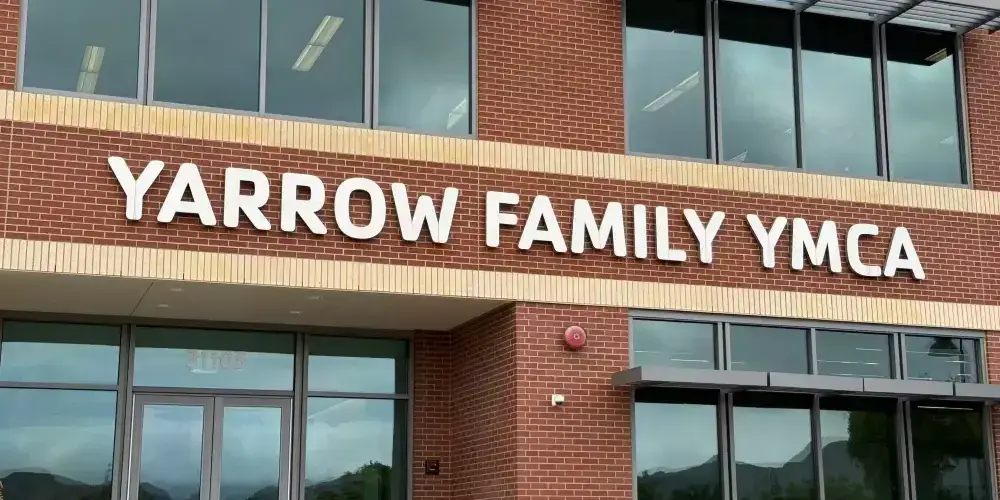 White Yarrow Family YMCA acrylic letters mounted on a brick building facade