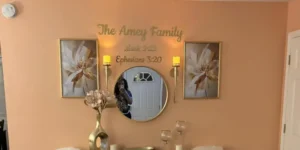 Gold mirror acrylic family name and date lettering arranged above a round wall mirror