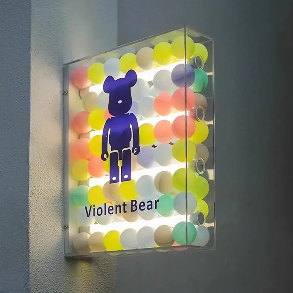 Transparent decorative light box filled with colored spheres and a purple bear graphic