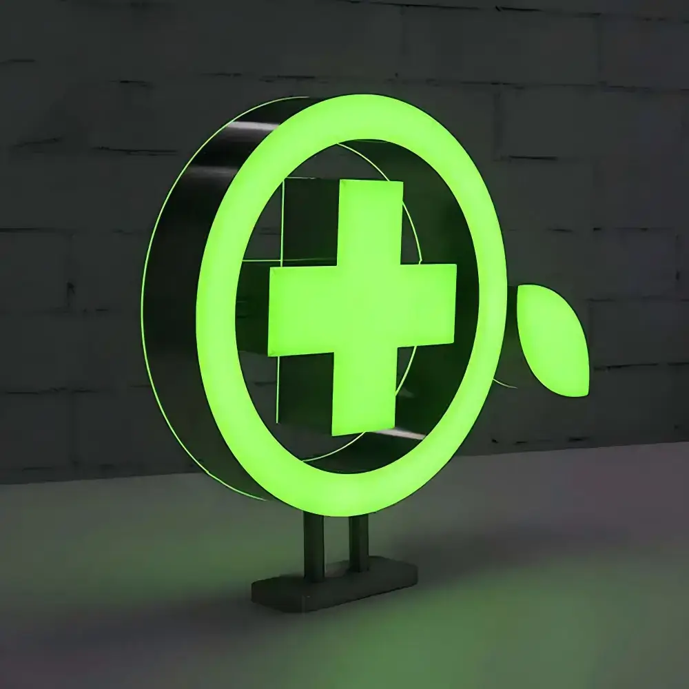 Green custom-shaped illuminated sign with a circular frame and cross symbol on a freestanding base