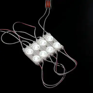 Double-lens LED sign modules connected by wires on a black background