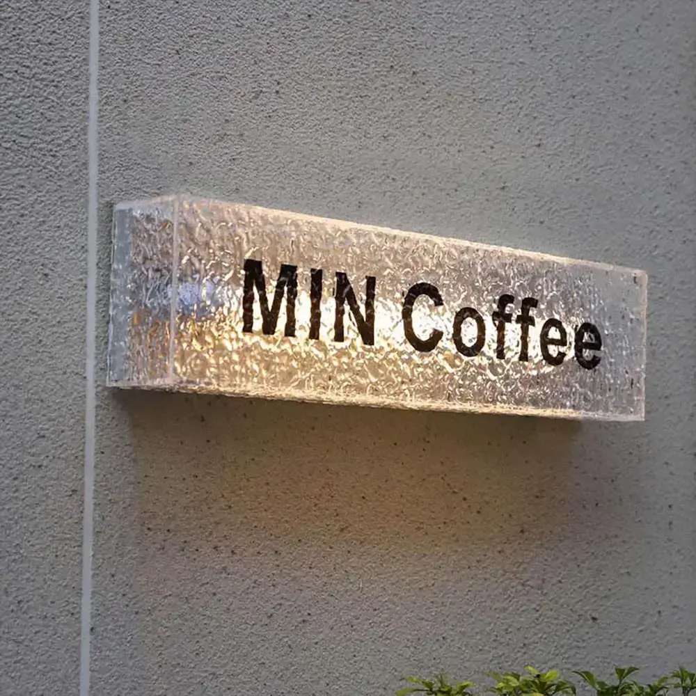 Textured full acrylic light box with warm illumination and black MIN Coffee lettering