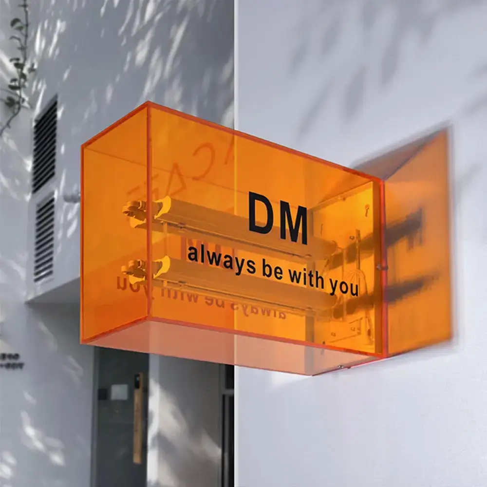 Transparent orange full acrylic light box with visible internal lamps and DM lettering