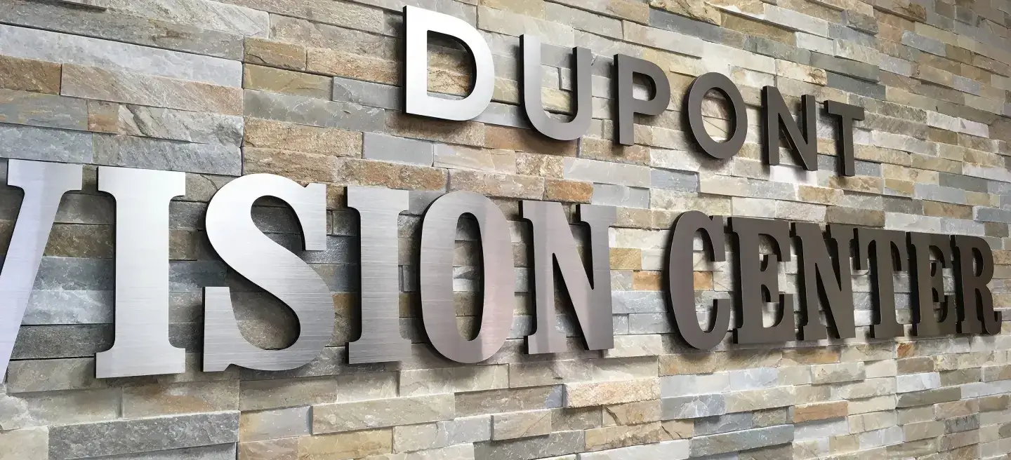 Dupont Vision Center brushed metal dimensional letters mounted on stacked stone wall