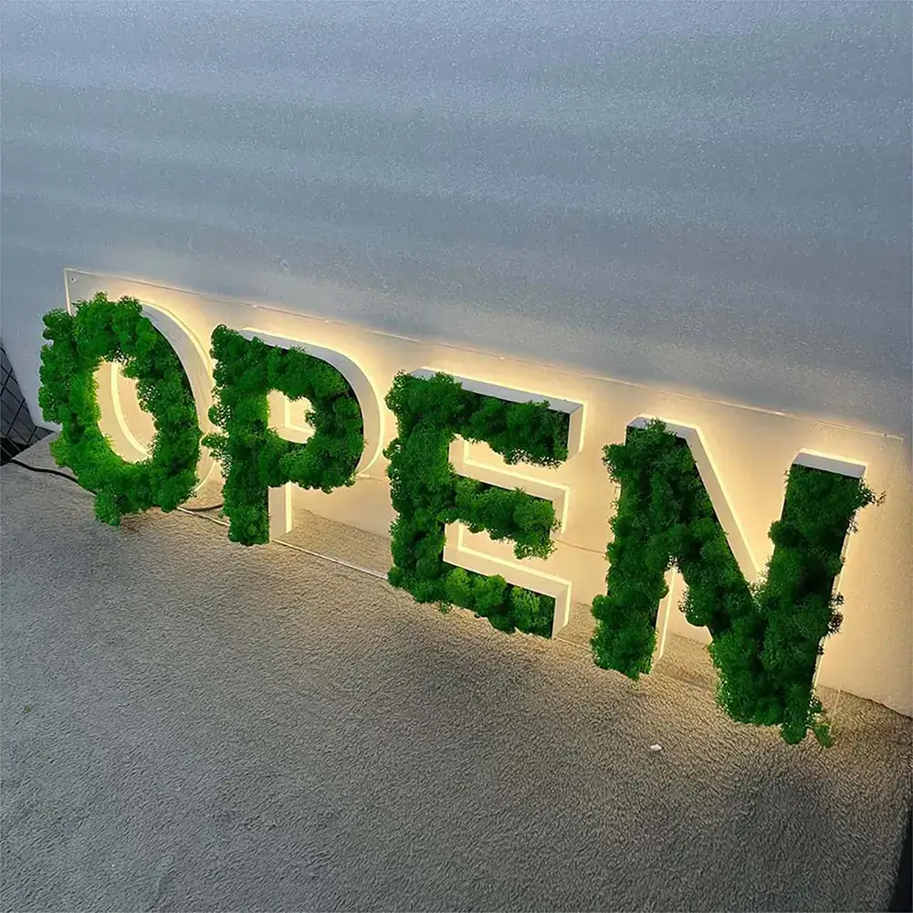 Green moss backlit OPEN letters with warm halo illumination