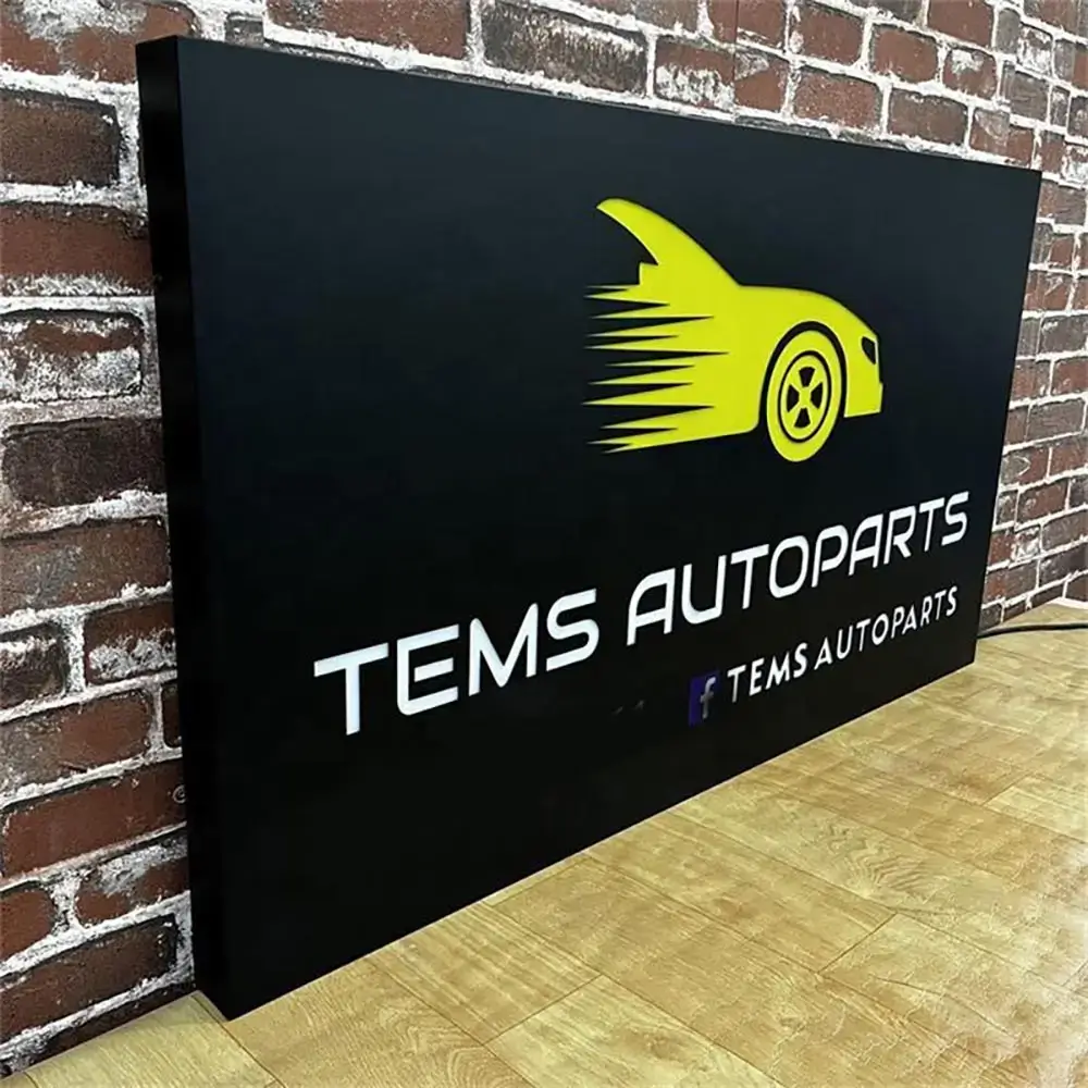 Black perforated metal light box with an illuminated yellow car graphic and TEMS Autoparts lettering