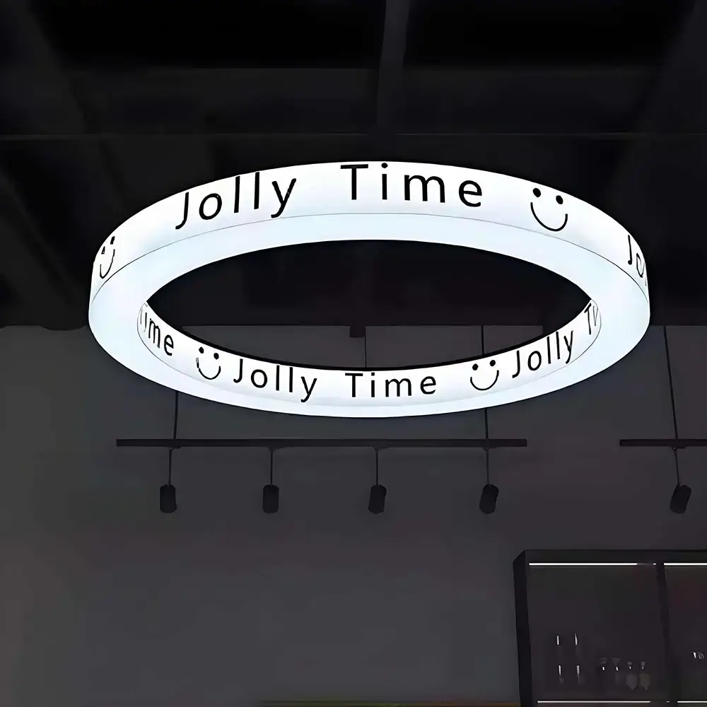 Suspended illuminated ring light box with repeating Jolly Time lettering and smile symbols