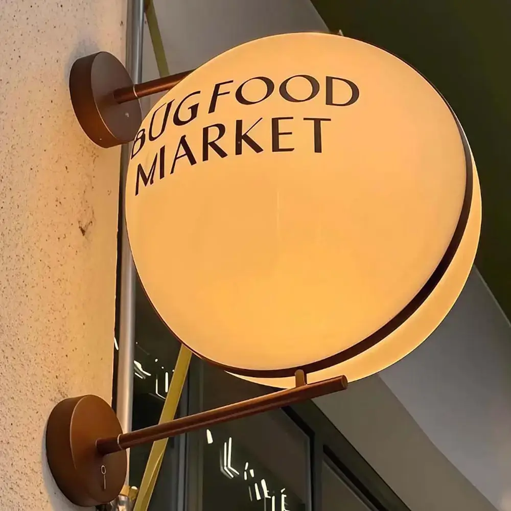 Warm white spherical projecting light box displaying Bug Food Market branding