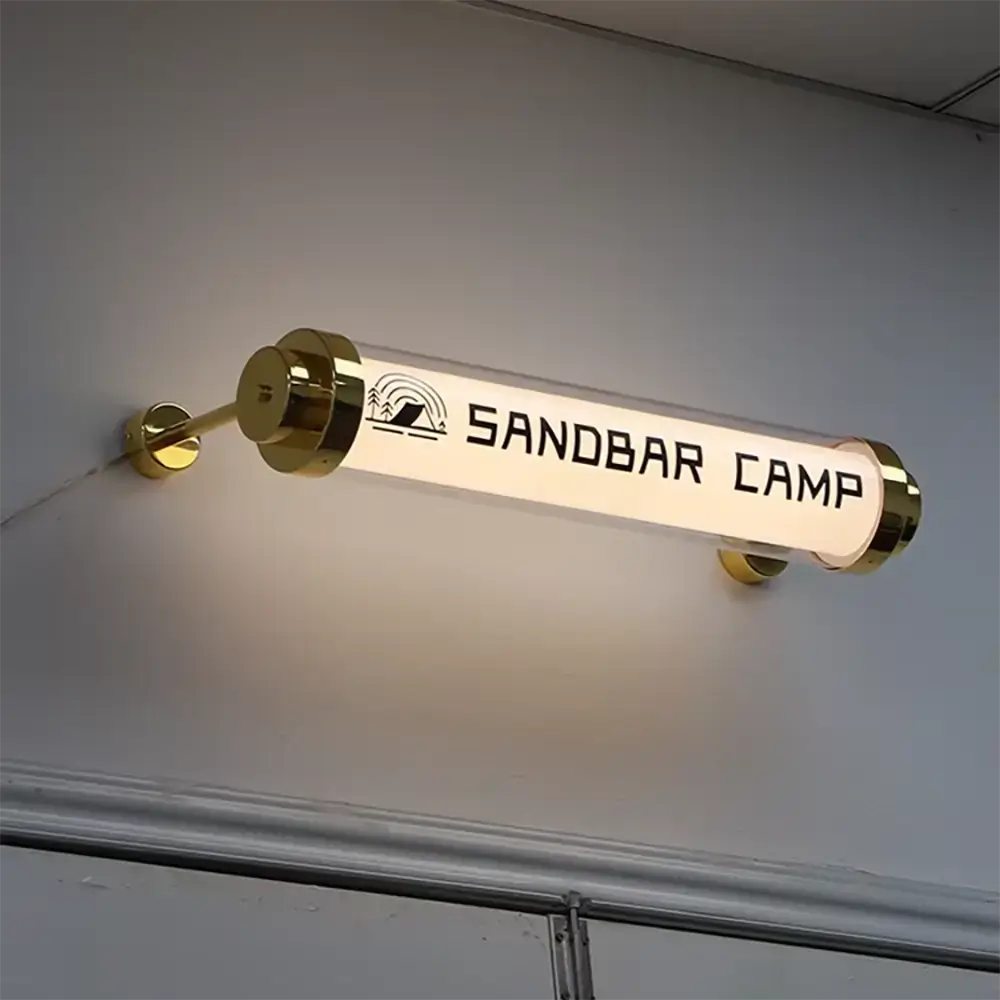 Horizontal tubular acrylic light box with Sandbar Camp graphics and gold end caps