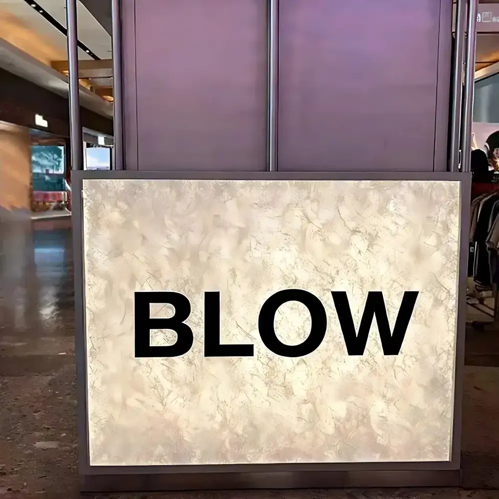 Illuminated Tyvek graphic panel with a translucent marbled texture and BLOW lettering
