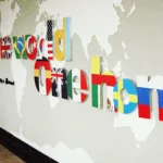 One World One Home dimensional letters printed with different national flag patterns on world map wall