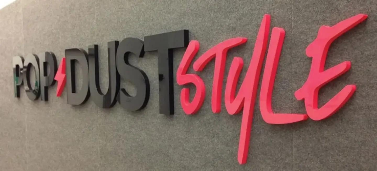 Black and red Popdust Style acrylic logo letters mounted on a gray interior wall