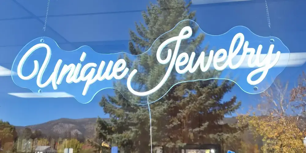 White Unique Jewelry LED neon sign suspended inside a storefront window