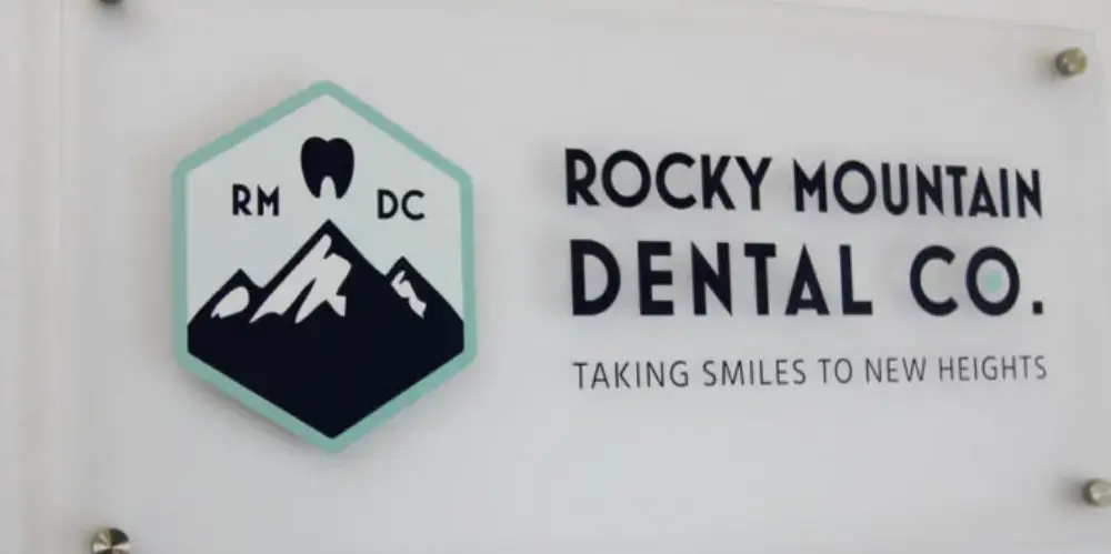 Rocky Mountain Dental Co sign with mountain hexagon logo and tooth icon on acrylic panel