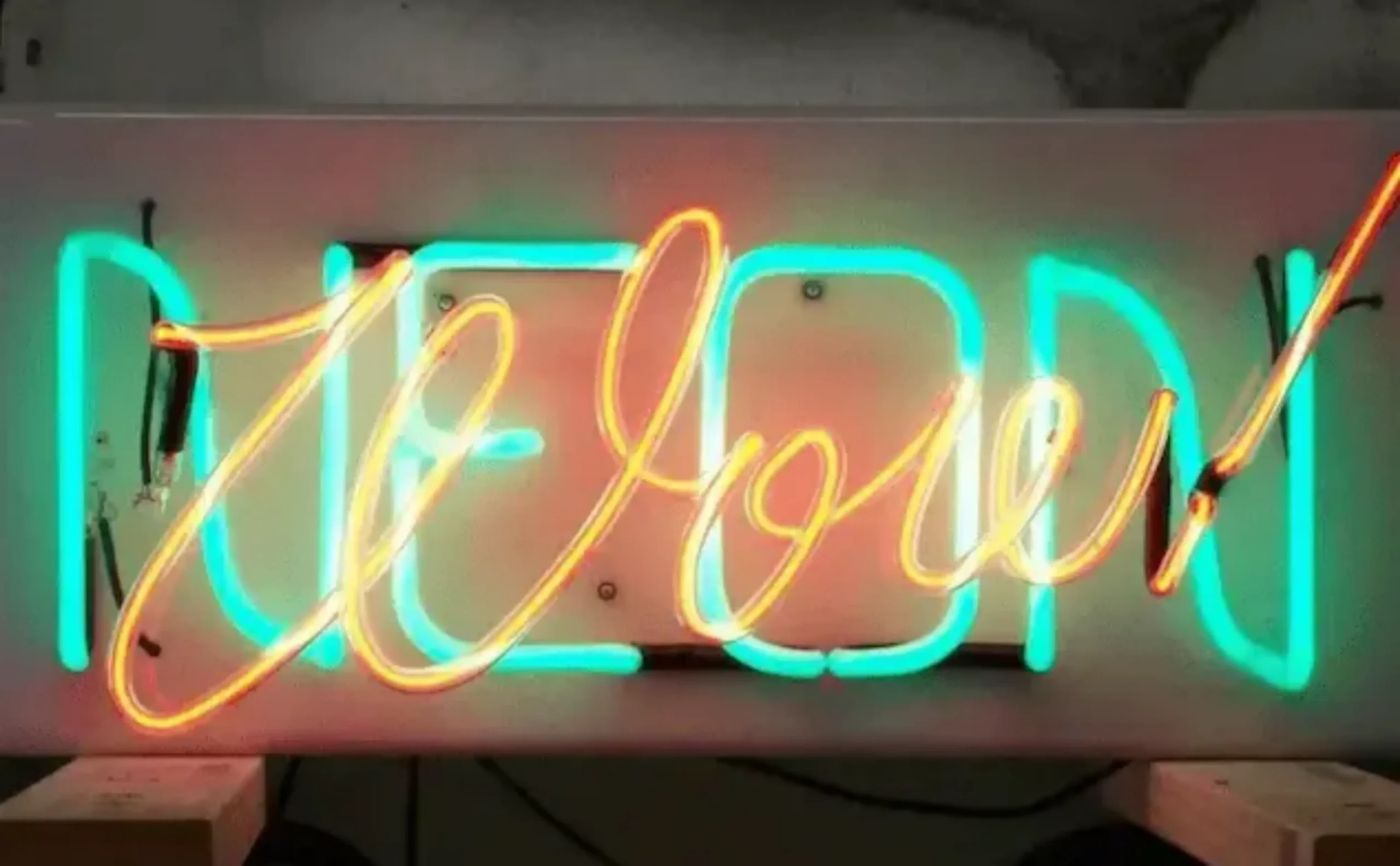 Custom real glass neon sign with orange script and turquoise illuminated tubing