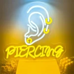 Yellow Piercing LED neon sign with white ear graphic on clear acrylic