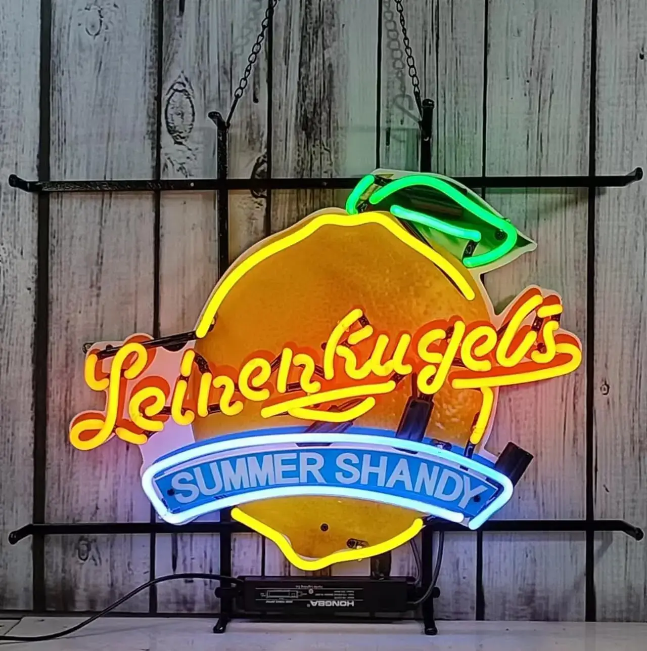Illuminated lemon sign with yellow lettering and blue Summer Shandy banner