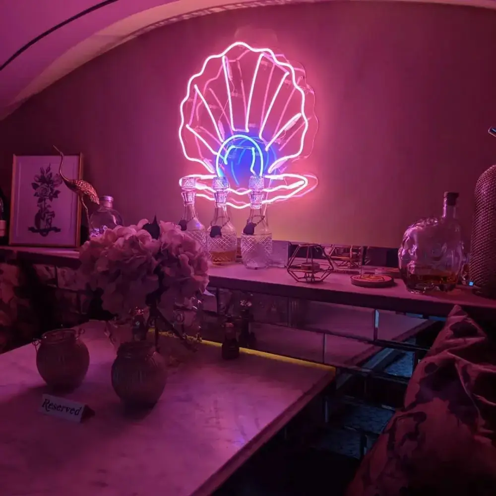 Neon artisan heating and bending a glass tube by hand over a flame